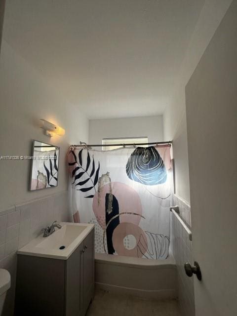 full bathroom with vanity, tile walls, shower / bathtub combination with curtain, and toilet