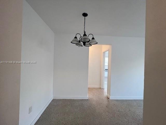 unfurnished dining area featuring a chandelier