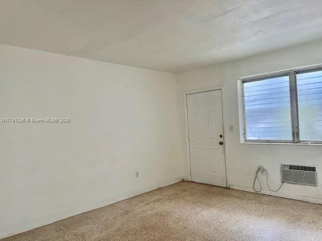 unfurnished room featuring a wall unit AC