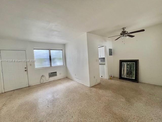 unfurnished living room with a wall unit AC and ceiling fan