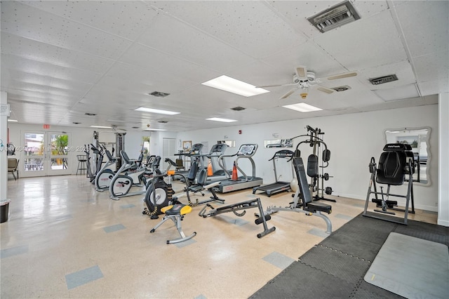 workout area with a paneled ceiling, ceiling fan, and french doors