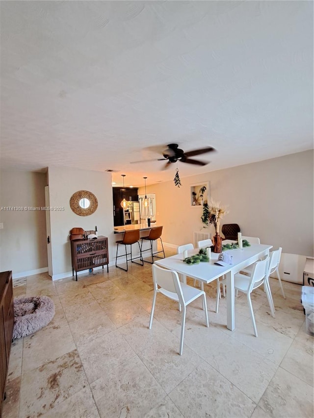 dining room with ceiling fan and baseboards