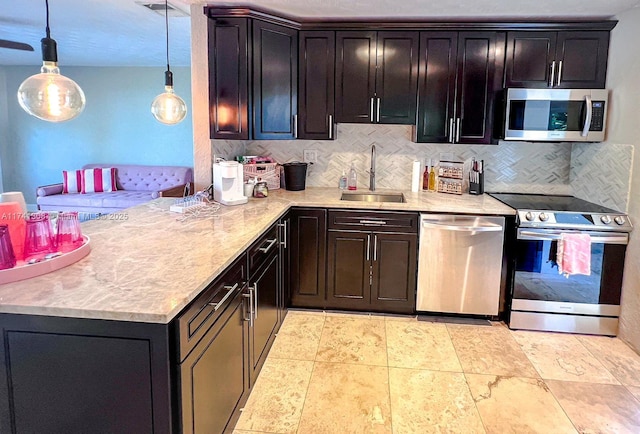 kitchen featuring dark brown cabinetry, tasteful backsplash, hanging light fixtures, stainless steel appliances, and a sink