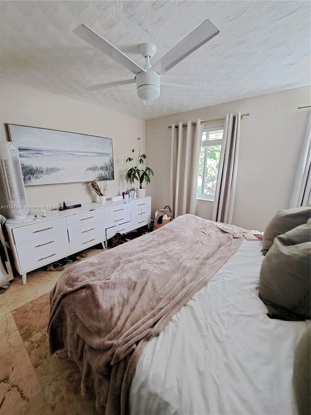 bedroom with ceiling fan and a textured ceiling