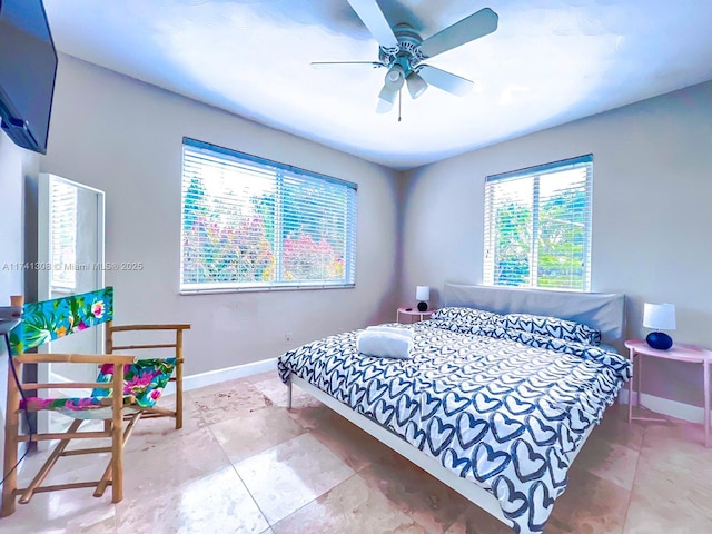 bedroom with ceiling fan and baseboards