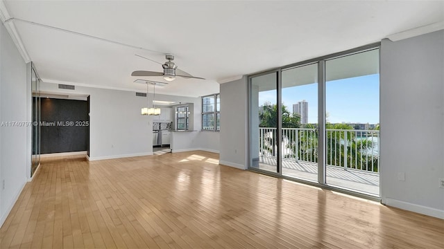 2801 NE 183rd St Unit 517W, Aventura, FL 33160 - unfurnished living room featuring ceiling fan, a chandelier, light wood-style flooring, ornamental molding, and baseboards