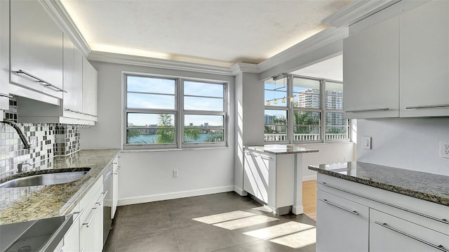 2801 NE 183rd St Unit 517W, Aventura, FL 33160 - kitchen featuring a sink, crown molding, healthy amount of natural light, tasteful backsplash, and stone counters