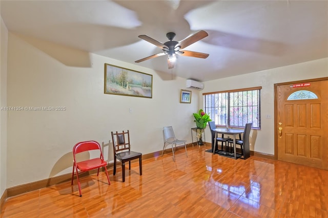 living area with hardwood / wood-style floors, a wall mounted AC, and ceiling fan