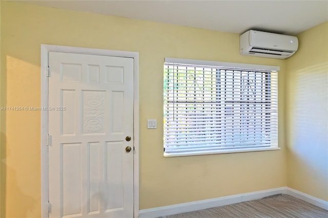 foyer entrance featuring a wall mounted air conditioner and a wealth of natural light