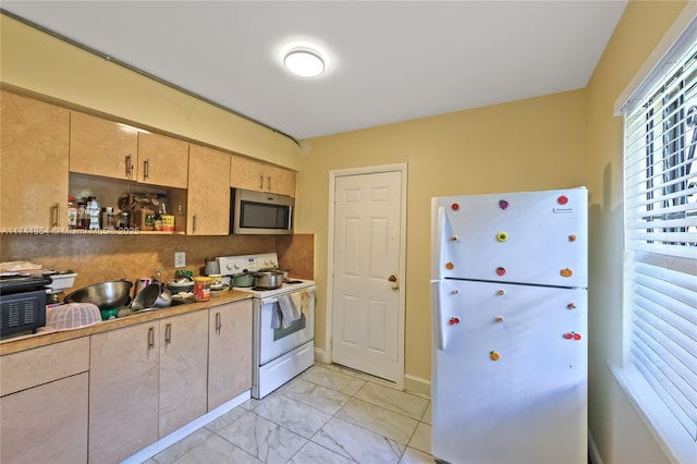 kitchen featuring light brown cabinetry, decorative backsplash, fridge, and white electric range oven