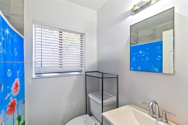 bathroom featuring a shower with curtain, vanity, and toilet