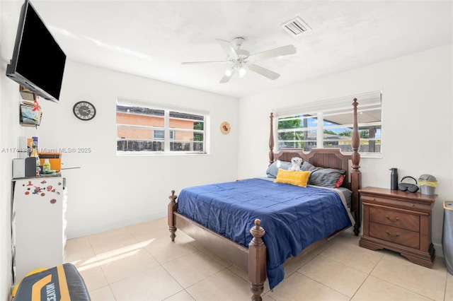 bedroom featuring ceiling fan, refrigerator, and light tile patterned floors