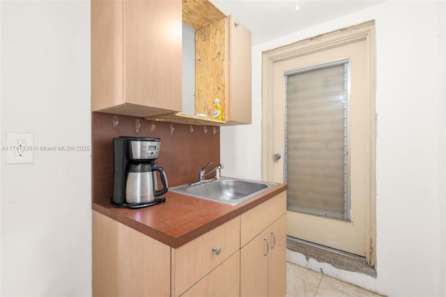 kitchen featuring sink, light tile patterned floors, and light brown cabinets