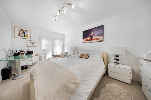 bedroom featuring rail lighting and light tile patterned floors