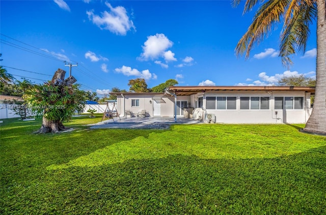 back of property with a yard and a patio area