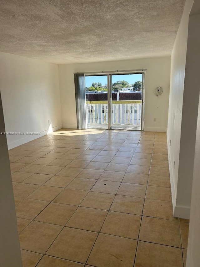 tiled empty room with a textured ceiling