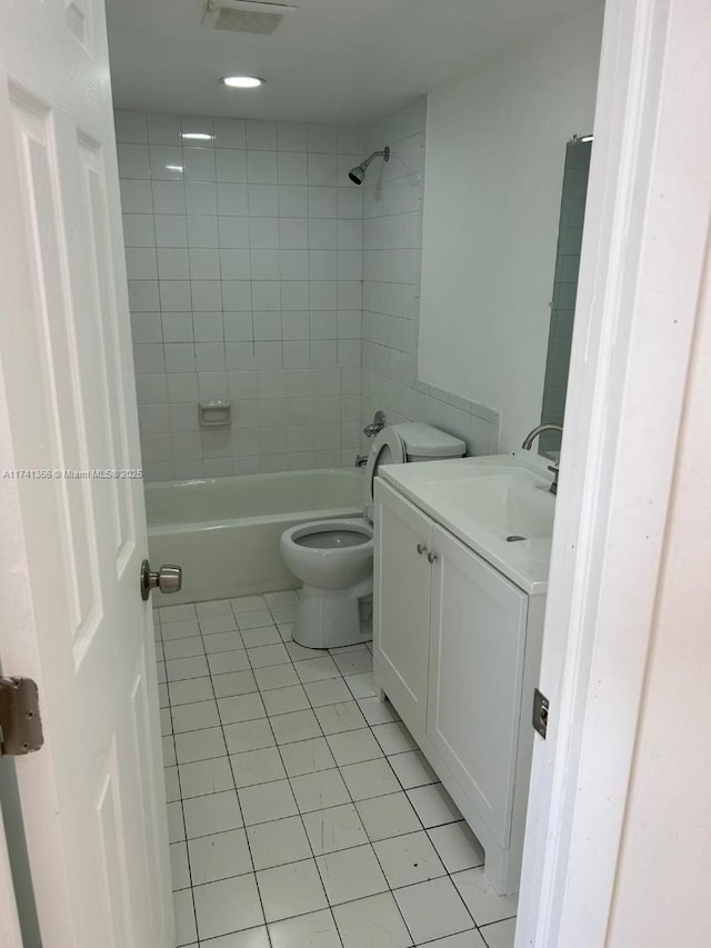 full bathroom with vanity, tiled shower / bath, tile patterned floors, and toilet