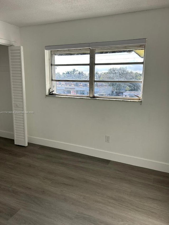 unfurnished bedroom featuring dark hardwood / wood-style floors and a textured ceiling