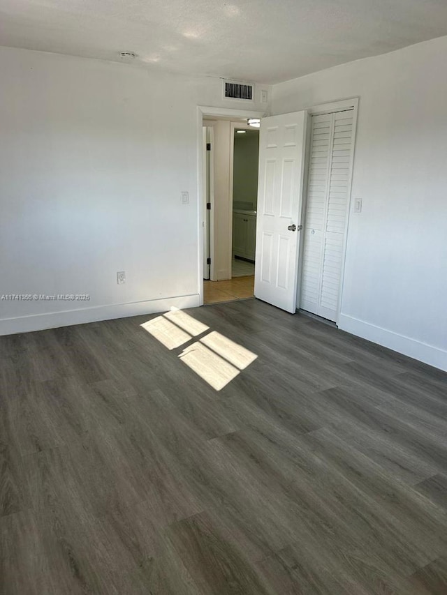 unfurnished room featuring dark wood-type flooring