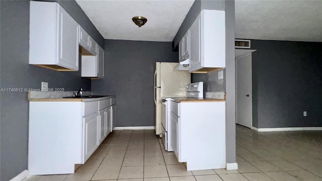 kitchen with sink, light tile patterned flooring, white cabinets, and white range with electric stovetop