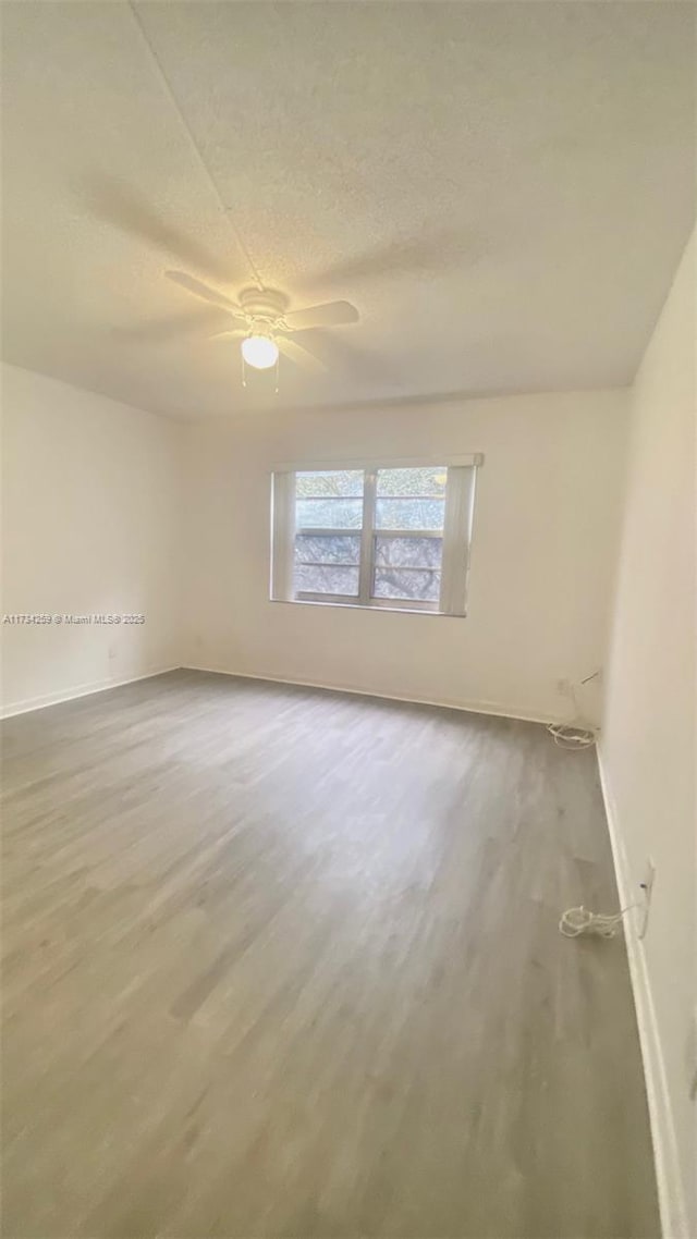 unfurnished room with ceiling fan, hardwood / wood-style floors, and a textured ceiling