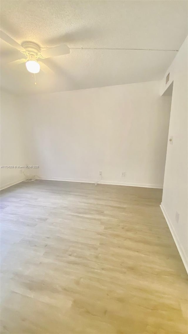spare room featuring ceiling fan, a textured ceiling, and light hardwood / wood-style floors
