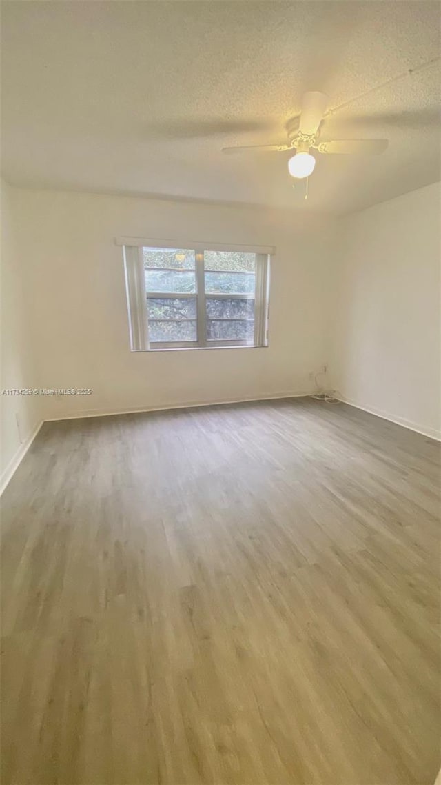 spare room with ceiling fan, hardwood / wood-style floors, and a textured ceiling