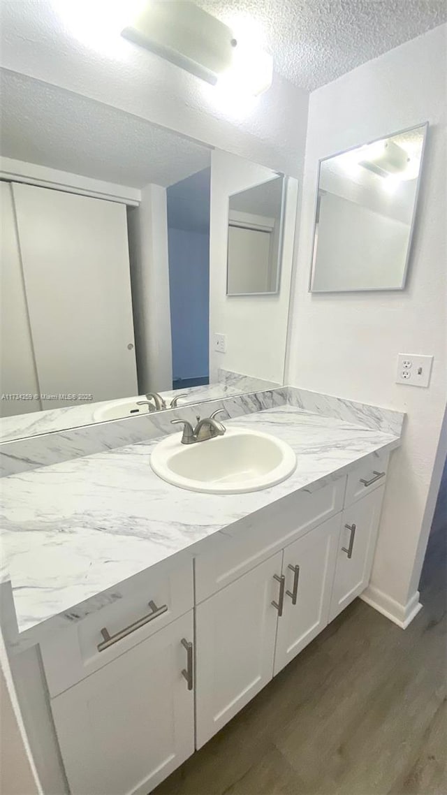 bathroom featuring vanity, hardwood / wood-style floors, and a textured ceiling
