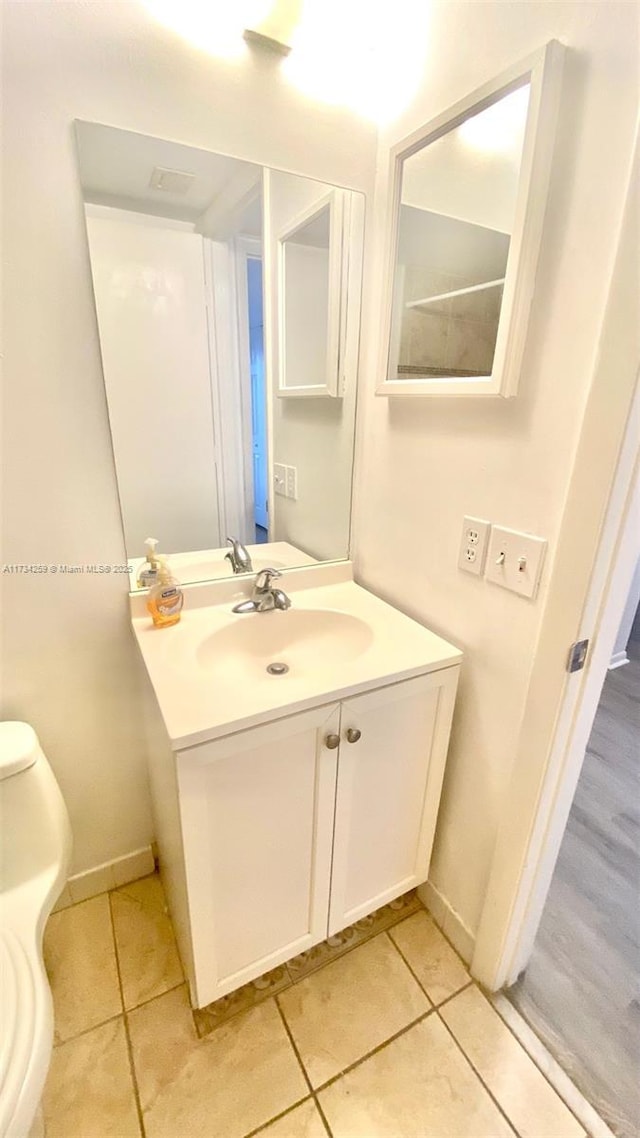 bathroom featuring vanity, tile patterned flooring, and toilet