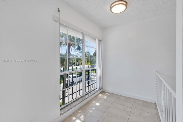 1194 Hillsboro Mile Unit 72, Hillsboro Beach, FL 33062 - spare room with a textured ceiling, light tile patterned floors, and baseboards