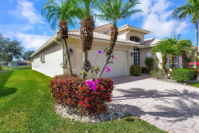 mediterranean / spanish-style house featuring a garage and a front yard