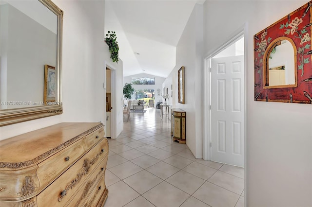 hallway with vaulted ceiling and light tile patterned floors