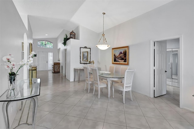 tiled dining area featuring high vaulted ceiling