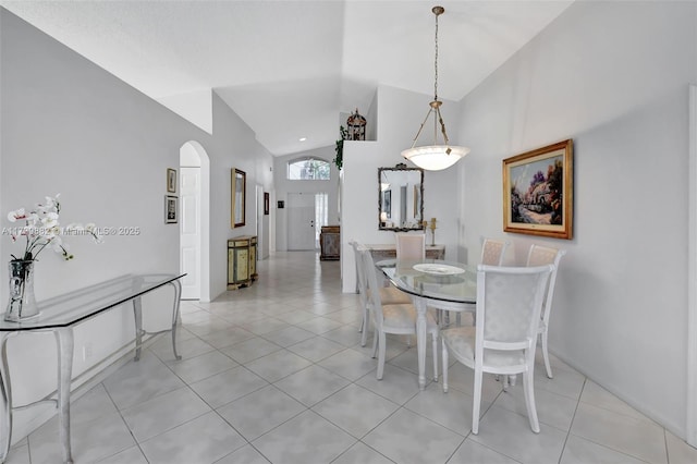 dining area featuring light tile patterned floors and high vaulted ceiling