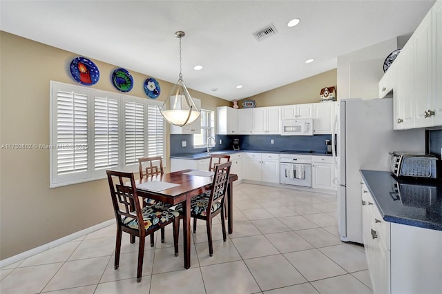 tiled dining space featuring lofted ceiling and sink