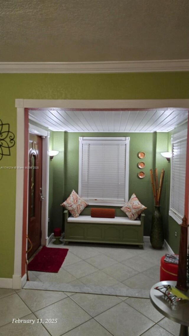 hallway featuring light tile patterned floors and ornamental molding