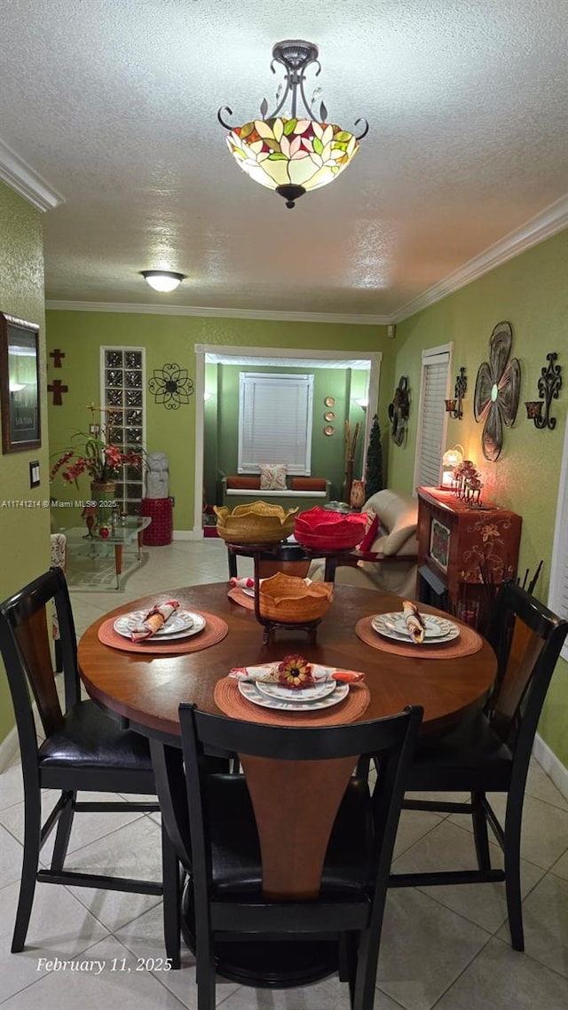 dining room with tile patterned flooring, ornamental molding, and a textured ceiling