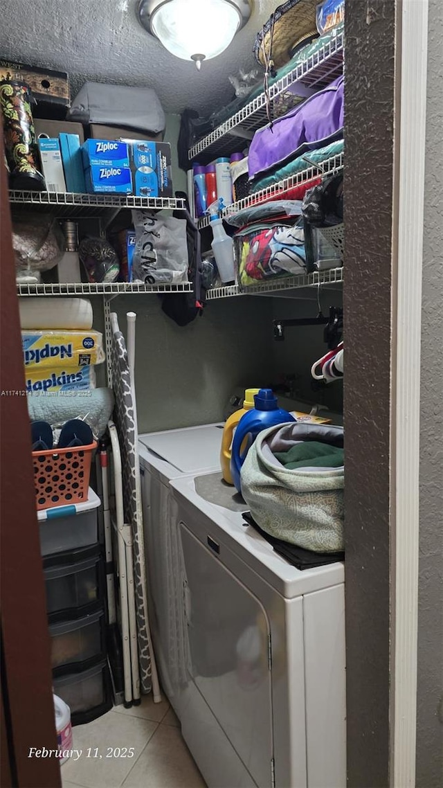 washroom featuring tile patterned flooring, washer and clothes dryer, and a textured ceiling