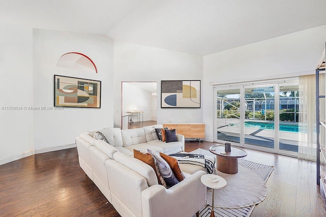 living room with dark hardwood / wood-style flooring and vaulted ceiling