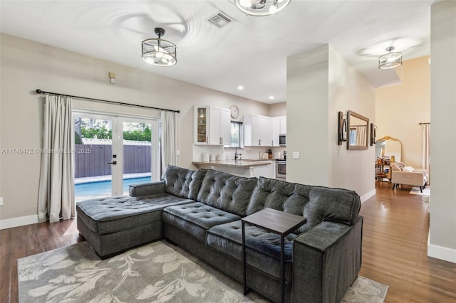 living room featuring french doors, wood-type flooring, and sink