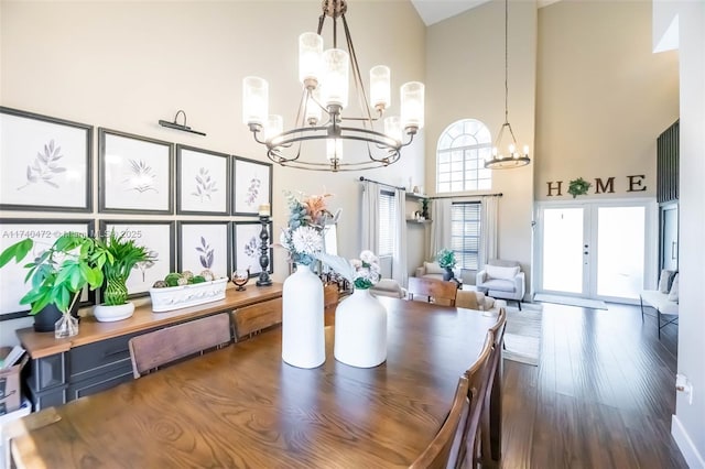 dining space with a notable chandelier, hardwood / wood-style floors, french doors, and a high ceiling