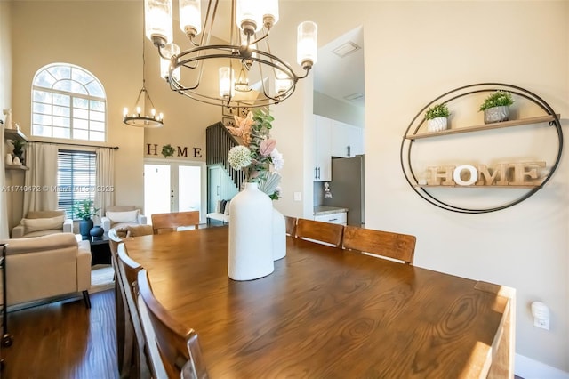 dining room with a notable chandelier, french doors, and a high ceiling