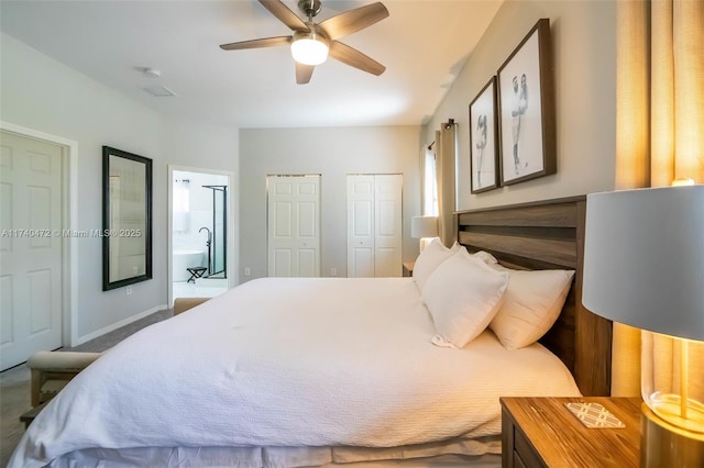 bedroom featuring ceiling fan, ensuite bath, and multiple closets