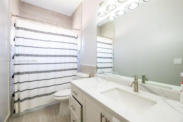 bathroom featuring vanity, walk in shower, and toilet