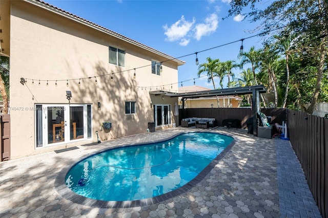 view of swimming pool with french doors, outdoor lounge area, a pergola, and a patio