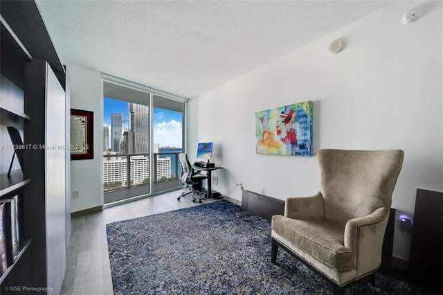 sitting room with wood-type flooring, floor to ceiling windows, and a textured ceiling