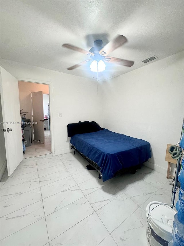 bedroom with ceiling fan and a textured ceiling