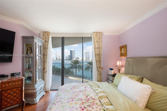 bedroom with expansive windows, ornamental molding, hardwood / wood-style floors, and access to exterior