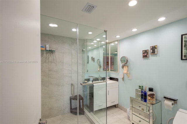 bathroom featuring walk in shower, vanity, and tile patterned flooring