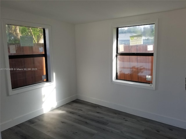 unfurnished room with dark hardwood / wood-style flooring